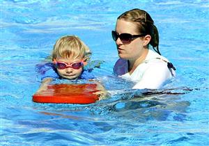 Young Boy Learning To Swim With A Body Board